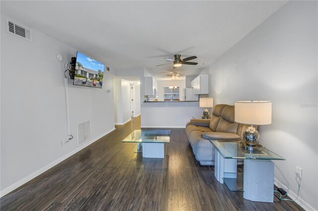 living room featuring dark wood-style floors, visible vents, ceiling fan, and baseboards