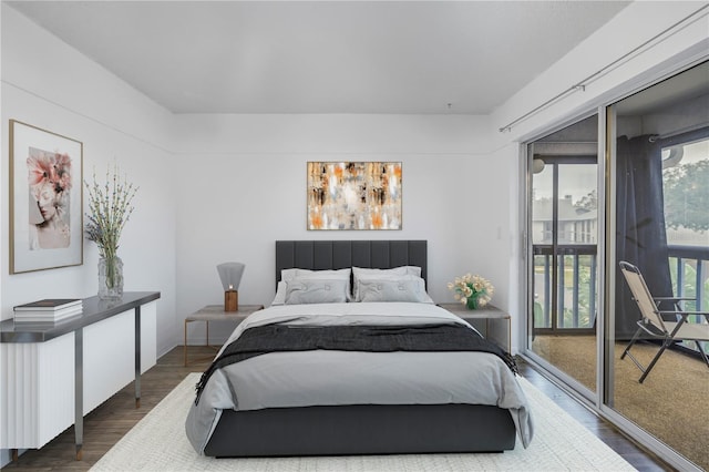 bedroom with dark wood-style floors and access to outside