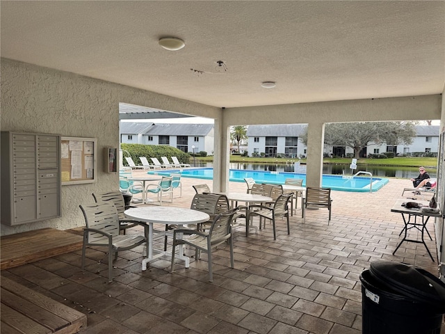 community pool with a patio and mail area