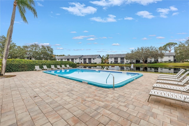 community pool featuring a residential view, a patio area, and a water view