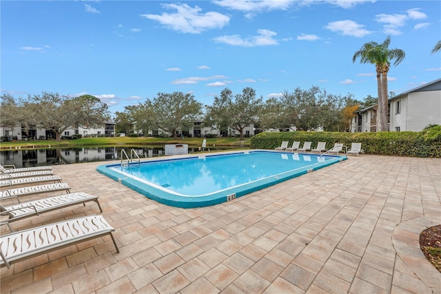 pool with a patio area and a water view