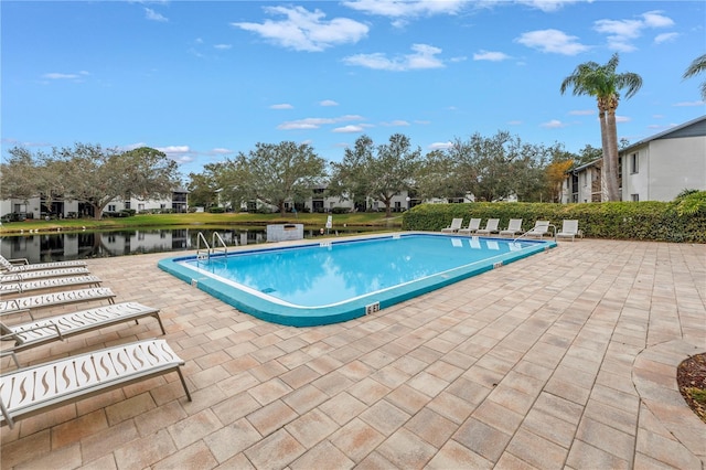 community pool featuring a residential view, a patio area, and a water view