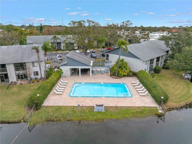 pool with a patio, a yard, and a residential view