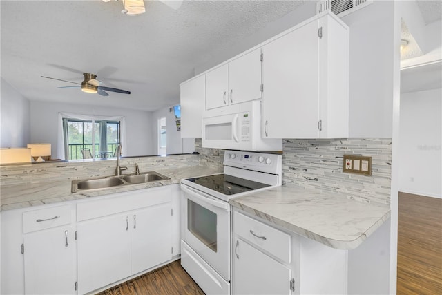 kitchen with white appliances, a sink, light countertops, decorative backsplash, and dark wood finished floors