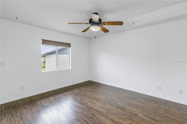 empty room featuring a ceiling fan, baseboards, dark wood finished floors, and a textured ceiling