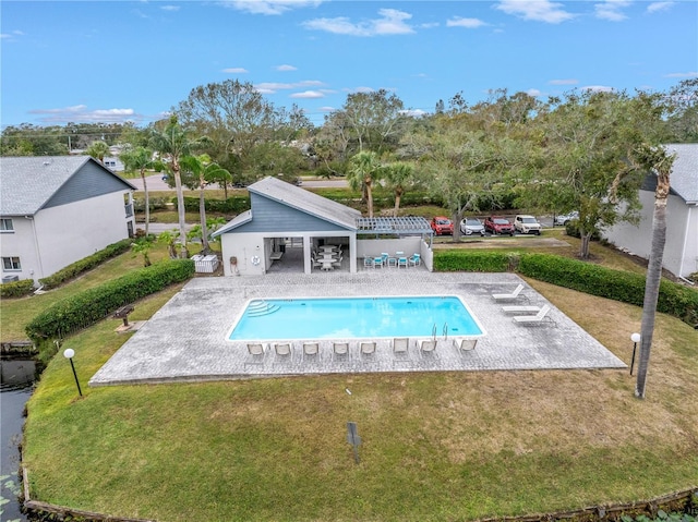 outdoor pool featuring a patio and a yard