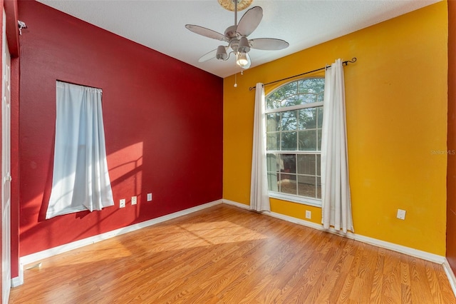 empty room with ceiling fan and hardwood / wood-style floors