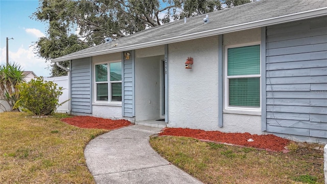 view of exterior entry featuring a yard