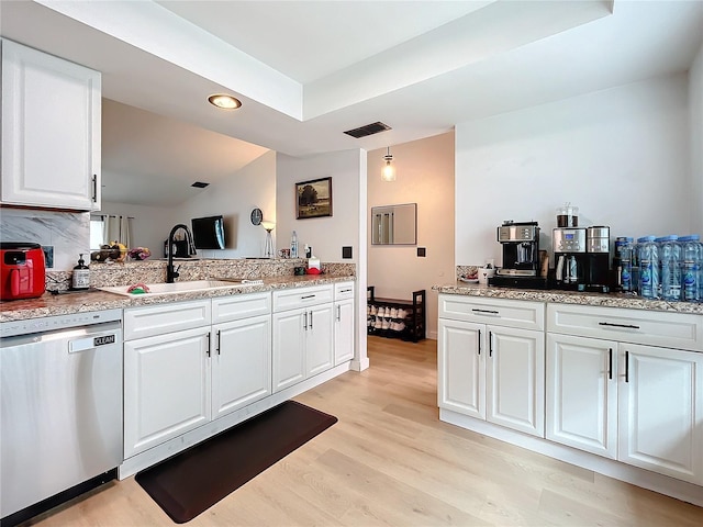 kitchen with dishwasher, white cabinetry, pendant lighting, sink, and light hardwood / wood-style flooring