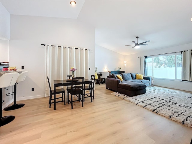 living room with lofted ceiling, ceiling fan, and light hardwood / wood-style flooring