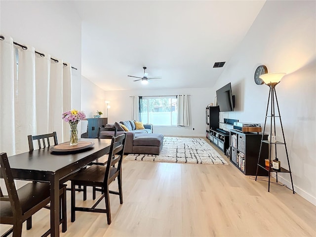 dining area featuring ceiling fan, light hardwood / wood-style floors, and vaulted ceiling