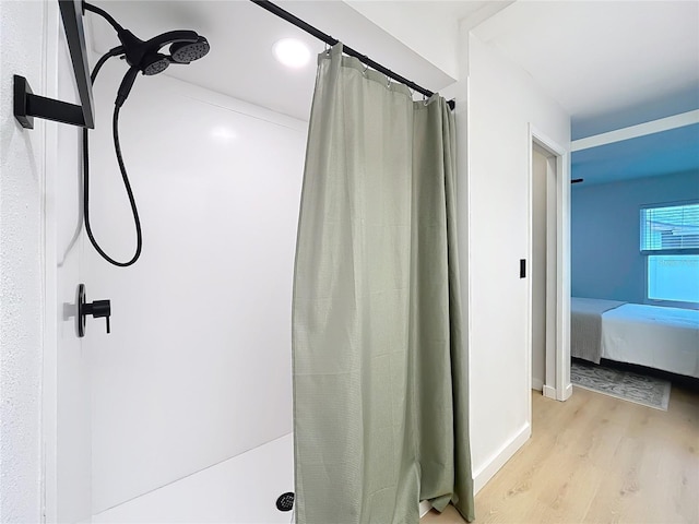 bathroom with hardwood / wood-style flooring and walk in shower