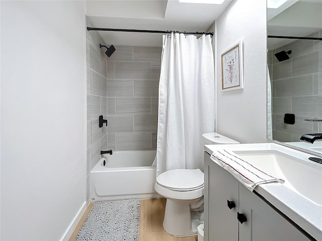 full bathroom featuring hardwood / wood-style floors, shower / bath combo with shower curtain, vanity, and toilet