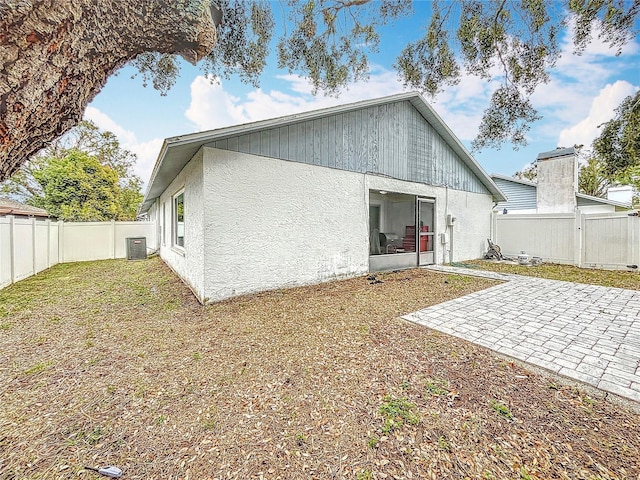 back of house with a lawn, central AC, and a patio