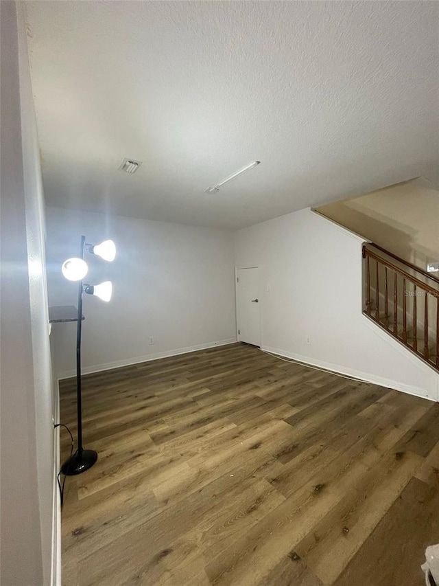 empty room featuring dark hardwood / wood-style flooring and a textured ceiling