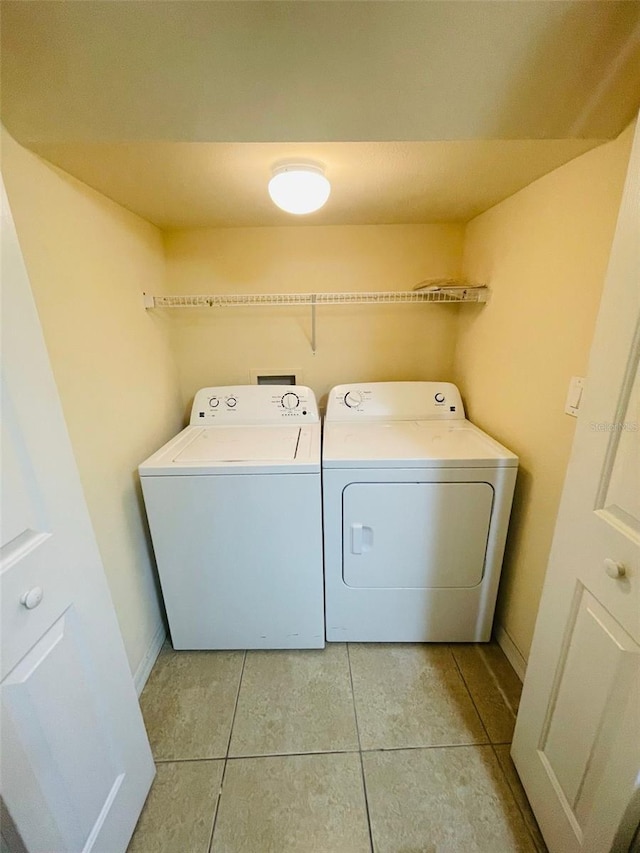 laundry area with washing machine and dryer and light tile patterned flooring