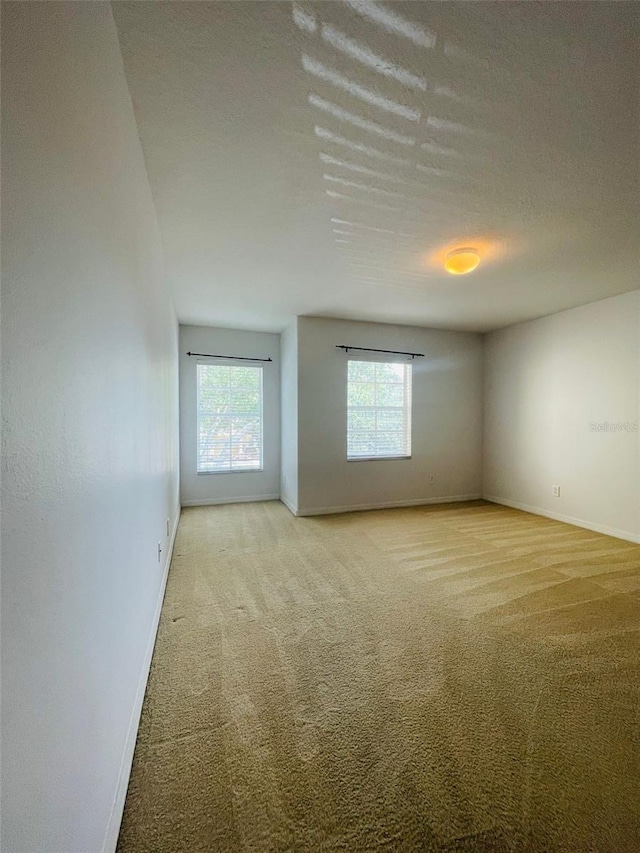 carpeted spare room with a textured ceiling