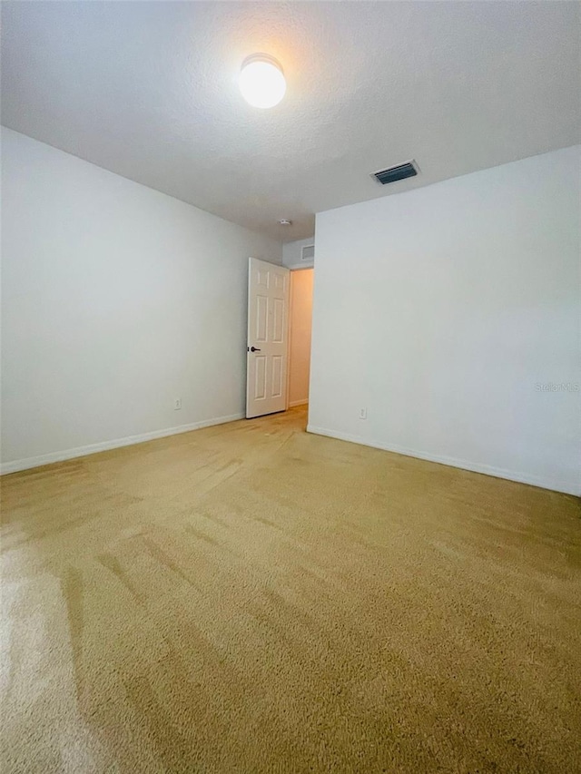 carpeted spare room with a textured ceiling