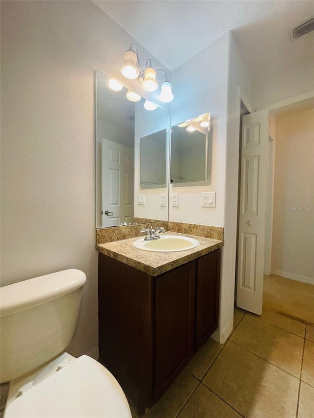 bathroom featuring toilet, vanity, and tile patterned floors