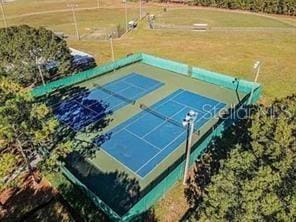 view of tennis court with a yard