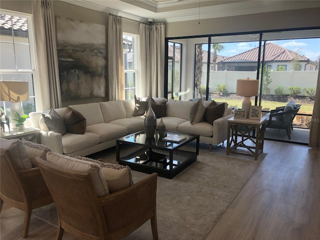 living room featuring wood-type flooring, a wealth of natural light, and ornamental molding