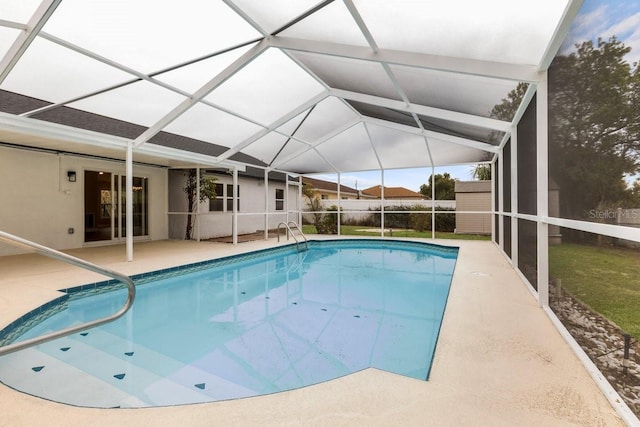 view of swimming pool with a storage unit, glass enclosure, and a patio