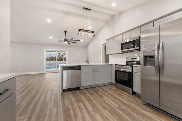 kitchen with light hardwood / wood-style flooring, lofted ceiling, gray cabinets, appliances with stainless steel finishes, and ceiling fan