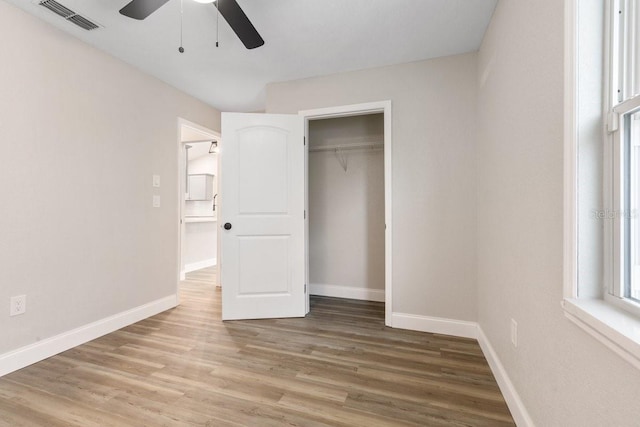 unfurnished bedroom featuring ceiling fan, a closet, and hardwood / wood-style floors