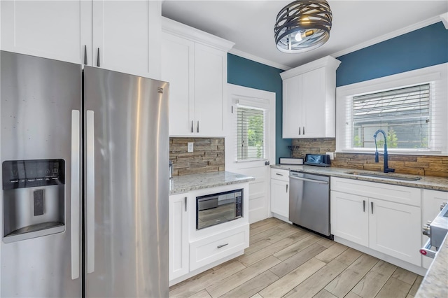 kitchen featuring stainless steel appliances, white cabinets, sink, and tasteful backsplash