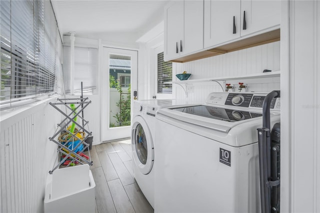 washroom featuring separate washer and dryer and cabinets