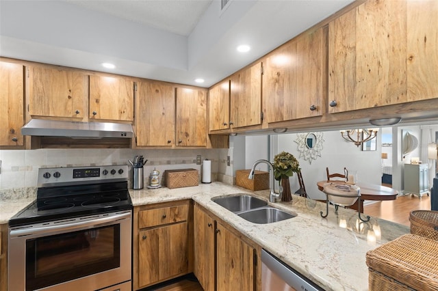 kitchen featuring light stone countertops, appliances with stainless steel finishes, decorative backsplash, sink, and hardwood / wood-style flooring