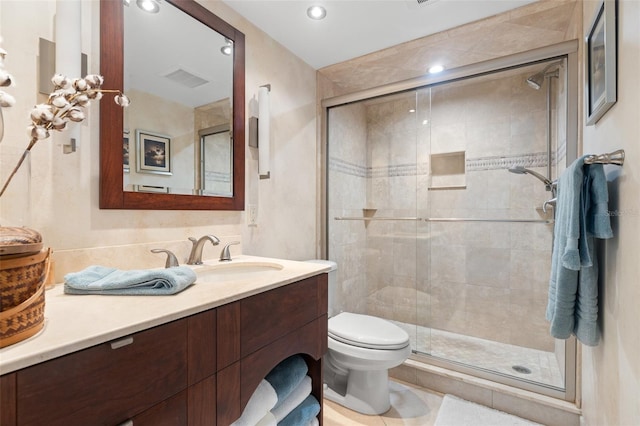 bathroom featuring toilet, tile patterned floors, a shower with shower door, and vanity