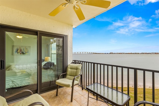 balcony with ceiling fan and a water view