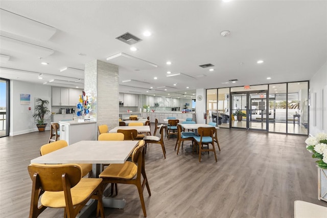 dining space featuring floor to ceiling windows and light hardwood / wood-style flooring