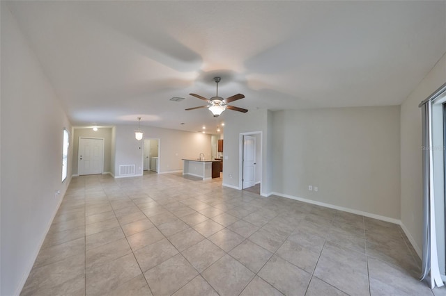 unfurnished living room featuring ceiling fan and light tile patterned floors