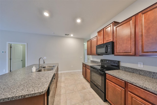 kitchen featuring sink, black appliances, a kitchen island with sink, and light tile patterned flooring