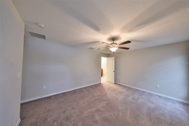 carpeted spare room featuring a textured ceiling and ceiling fan