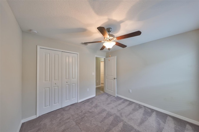 unfurnished bedroom featuring light colored carpet, a closet, and ceiling fan