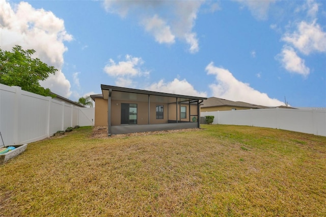 back of house featuring a sunroom and a lawn