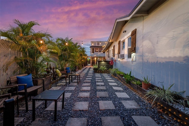 patio terrace at dusk featuring cooling unit