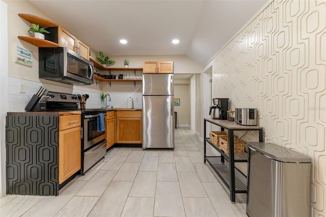 kitchen with lofted ceiling, stainless steel appliances, and sink