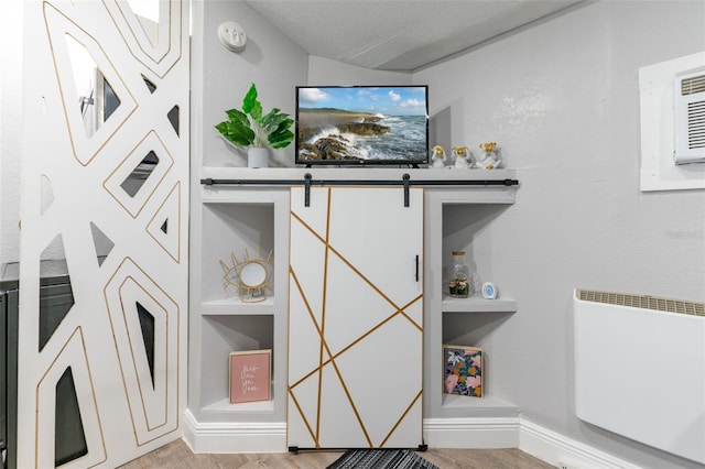 room details featuring wood-type flooring, built in features, and a textured ceiling