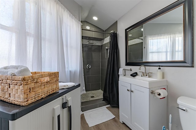 bathroom with lofted ceiling, hardwood / wood-style floors, vanity, a shower with curtain, and toilet