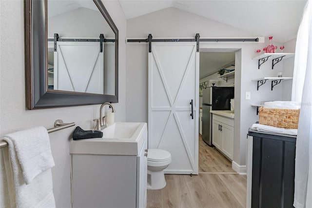 bathroom with vanity, hardwood / wood-style floors, vaulted ceiling, and toilet