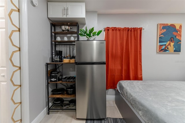 bedroom with stainless steel refrigerator