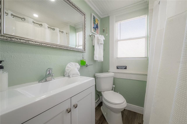 bathroom featuring vanity, hardwood / wood-style floors, ornamental molding, and toilet