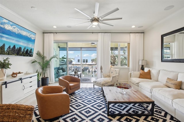 living room featuring light wood-type flooring, ceiling fan, and ornamental molding