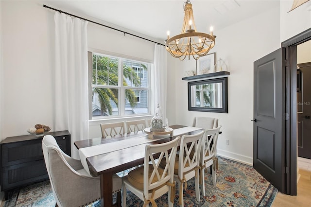 dining area featuring an inviting chandelier and light hardwood / wood-style flooring