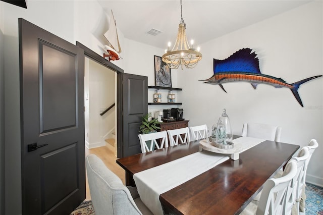 dining space featuring a chandelier and light hardwood / wood-style flooring