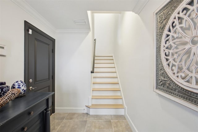 staircase featuring crown molding and tile patterned floors